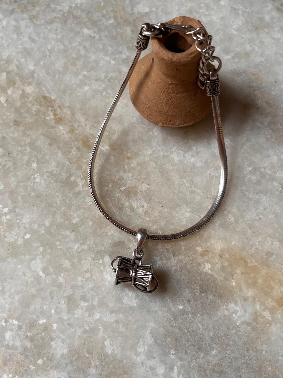 Elegant 925 sterling silver rakhi with damru charm and sleek chain, symbolizing tradition and protection.