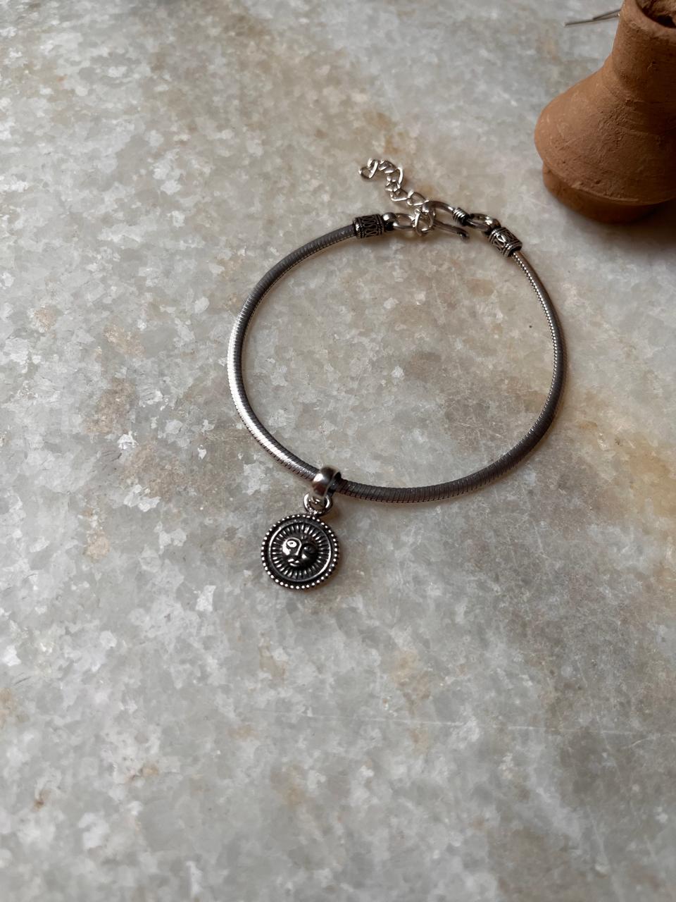 Elegant sterling silver bracelet with a charm, showcasing intricate design and timeless beauty.