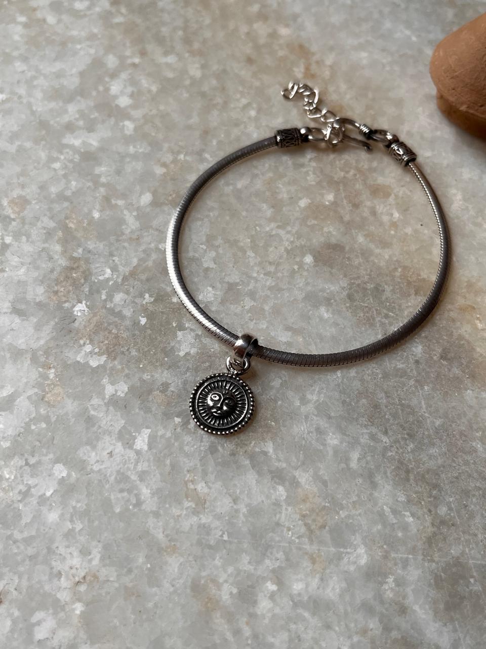 Elegant 925 sterling silver bracelet featuring a round charm with intricate design, symbolizing protection and strength.
