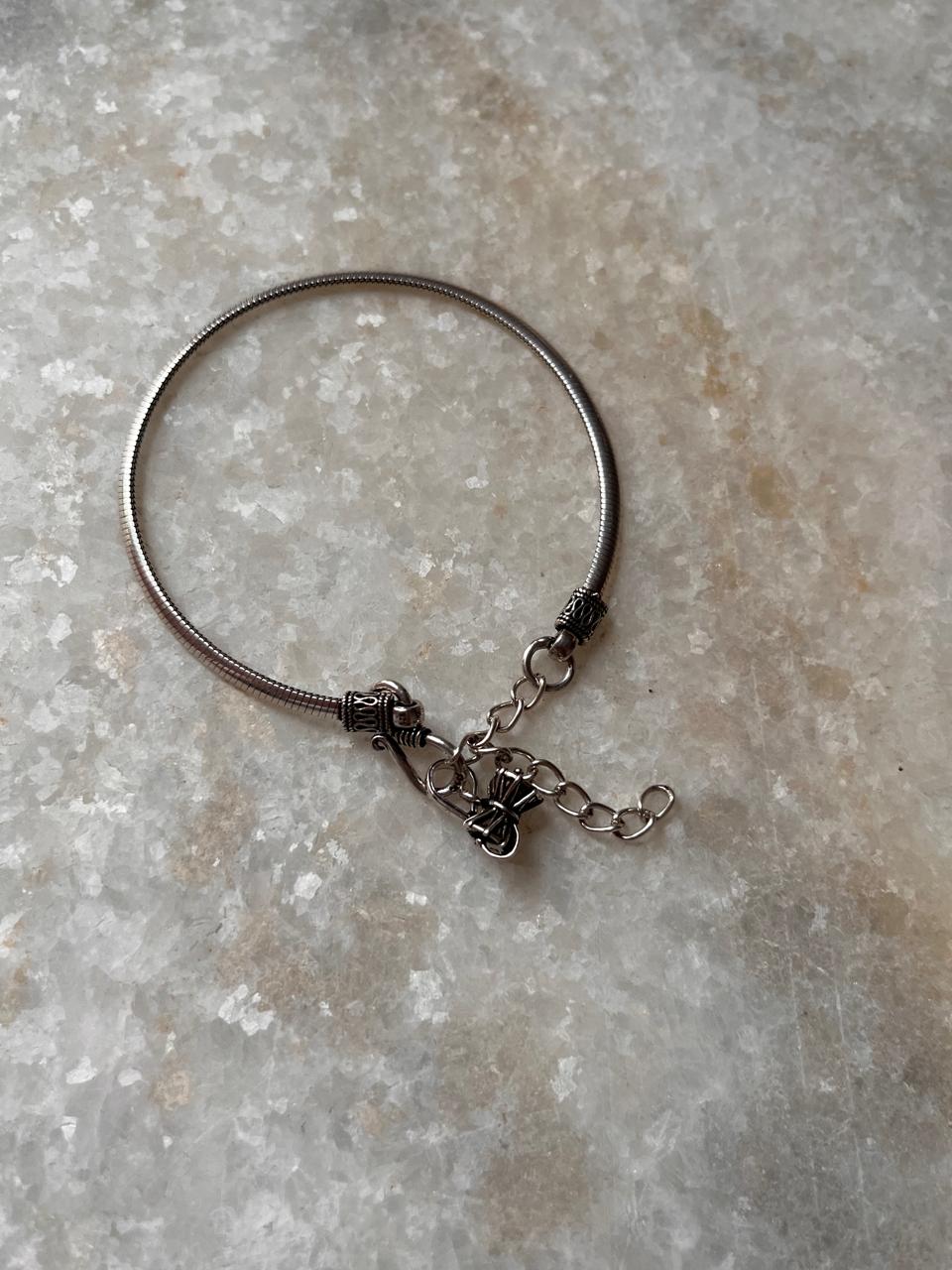 Antique finish silver rakhi with snake pattern and Damru charm