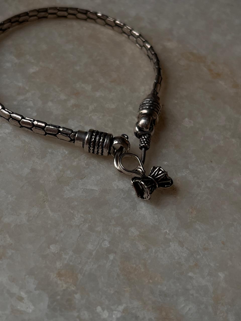 Antique silver rakhi with snake pattern and small Shiva Damru 