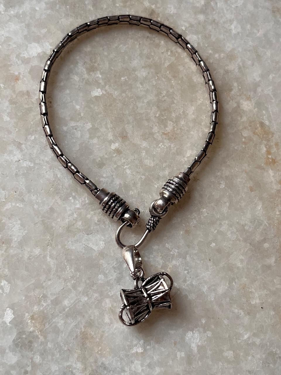 Snake motif rakhi with Shiva Damru charm in silver