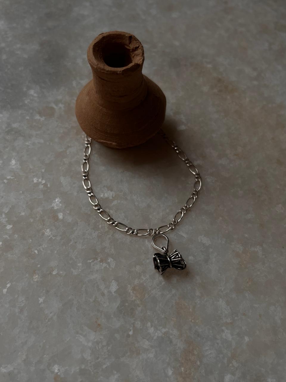 Small Damru rakhi on classic Figaro chain in silver