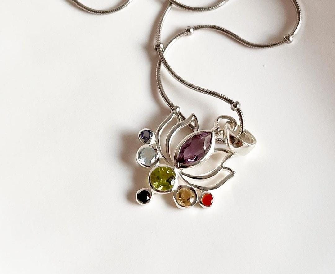 Seven chakra gemstones set in lotus-shaped silver pendant