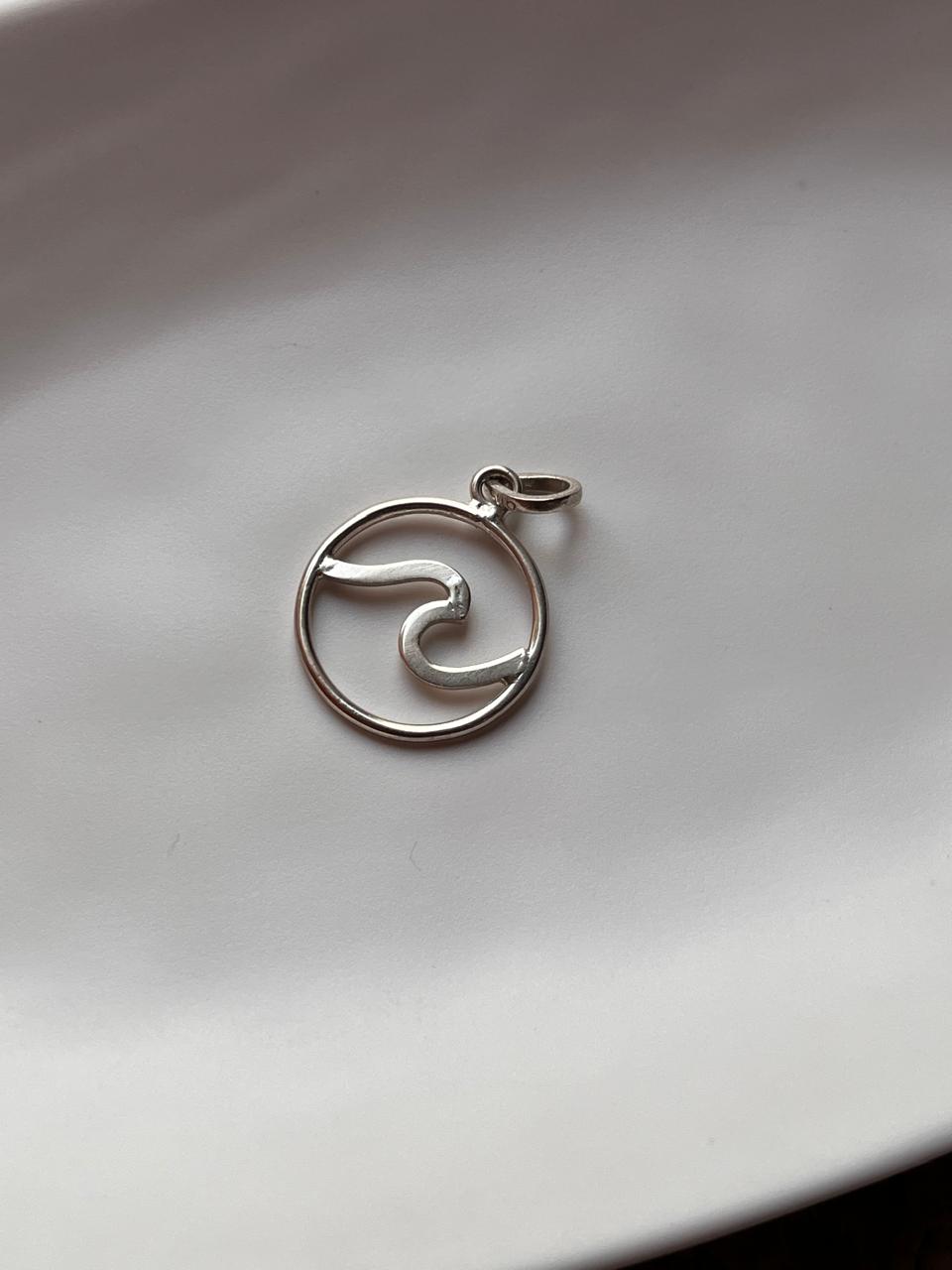 Sleek wave pattern in round silver pendant