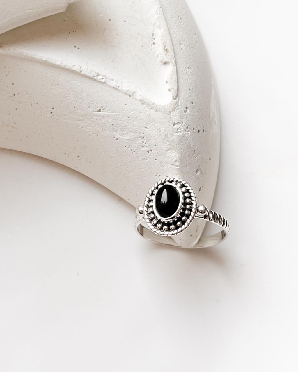 Black Onyx Rawa Tribal Silver Ring with intricate silver detailing on a minimalist surface.