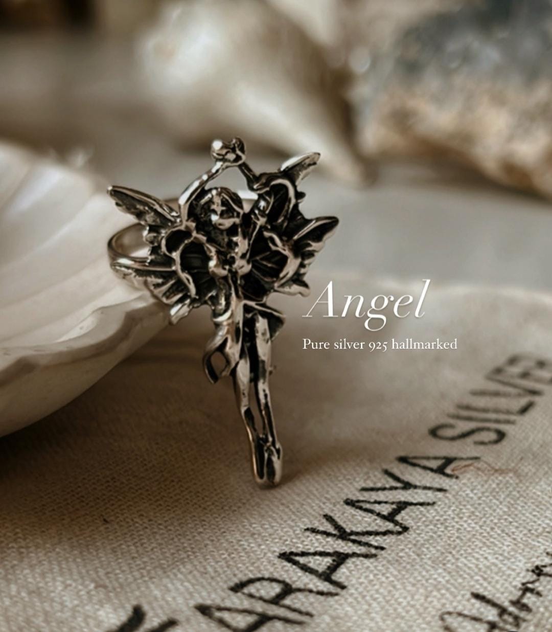 Elegant angel-themed adjustable ring in polished silver.