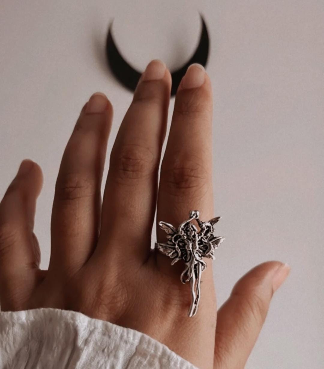 Sleek adjustable silver ring with an angel figure for a meaningful look.