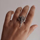 Adjustable silver ring with an angel silhouette for a celestial touch.