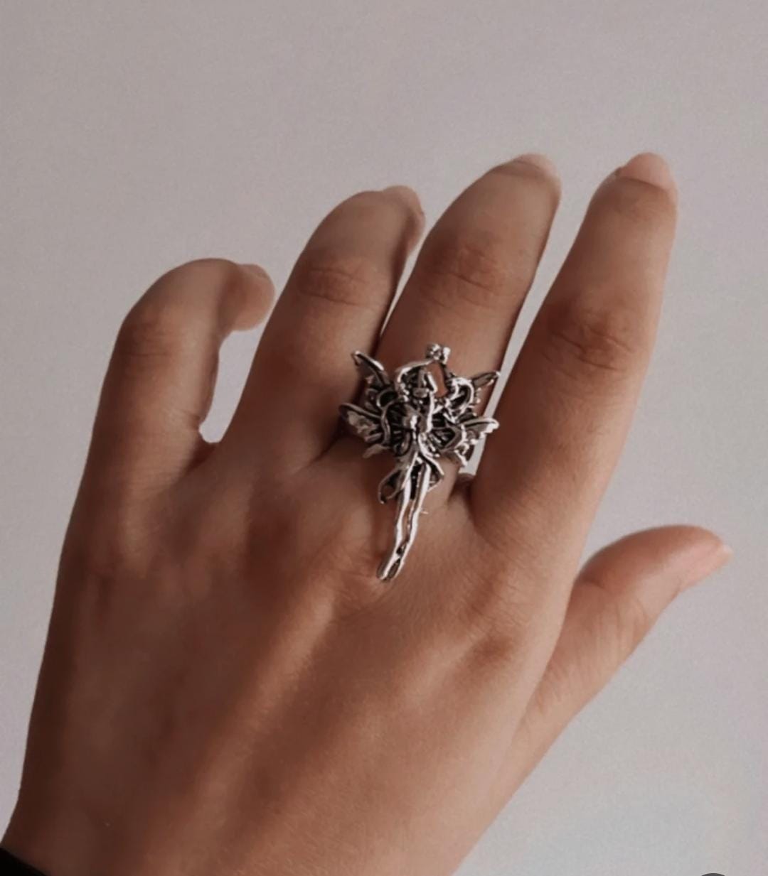 Adjustable silver ring with an angel silhouette for a celestial touch.