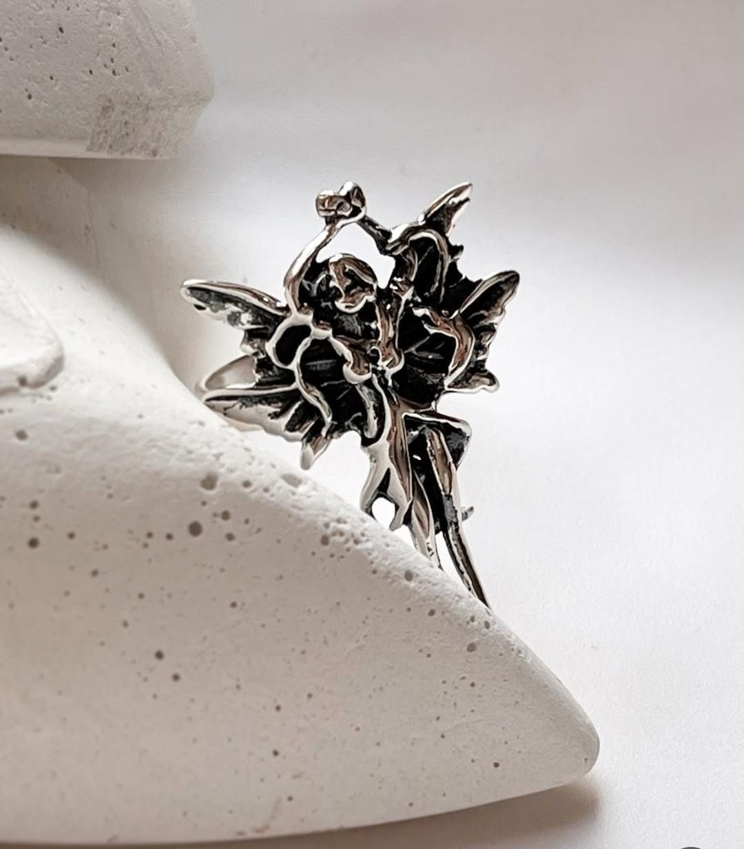 Charming silver adjustable ring with angel wings design.