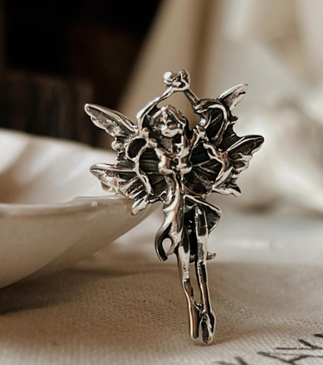 Charming silver adjustable ring with angel wings design.