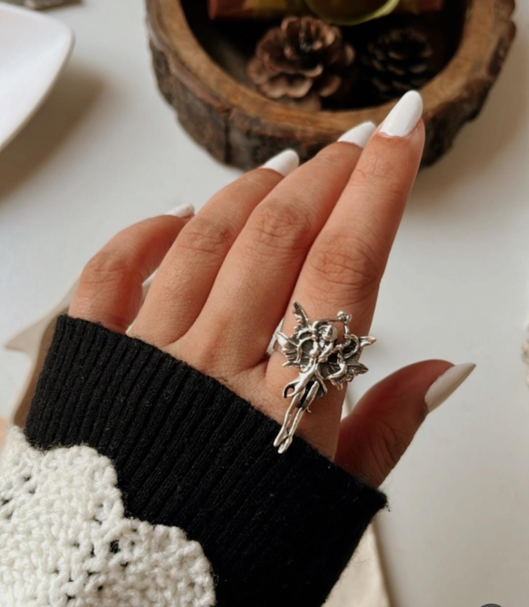 Adjustable silver ring with an angel silhouette for a celestial touch.