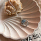 Sleek silver pendant with a vibrant aquamarine stone in boho style.