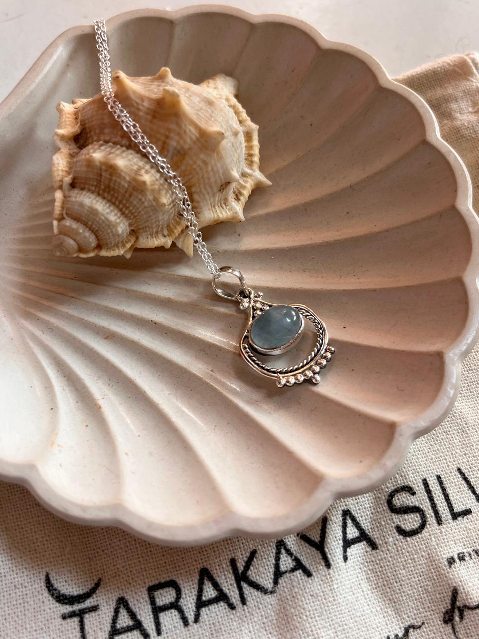 Sleek silver pendant with a vibrant aquamarine stone in boho style.