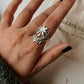 Elegant chunky silver ring featuring a detailed floral garden pattern.