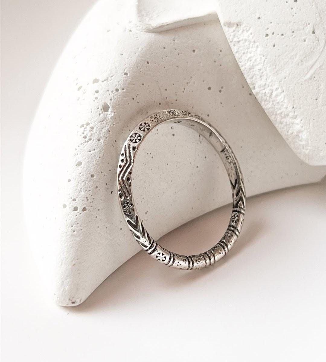 Tribal Edge 925 silver ring displayed on a textured surface, showcasing intricate designs and unique craftsmanship.