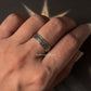 Hand wearing a decorative Sacred Journey 925 silver ring with intricate design against a star background.