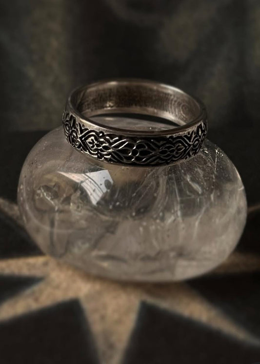 Sacred Journey 925 sterling silver ring displayed on a decorative stone, showcasing its unique engraved design and pure silver quality.