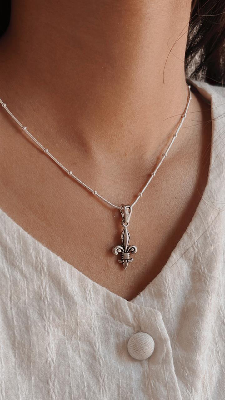 Unique Fleur De Lis silver pendant with a detailed, ornamental design
