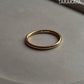 Gold vermeil plain round stack band ring on a neutral background, showcasing its shine and elegant design.