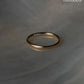 Gold vermeil plain round stack band ring on a marble surface, showcasing its elegant design and durability.