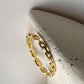 Gold vermeil thin link stack band ring displayed on a minimalist concrete stand.