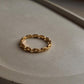 Gold vermeil thin link stack band ring on a neutral surface, showcasing its durable and elegant design.