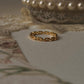 Gold vermeil thin link stack band ring displayed elegantly on vintage lace background.