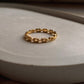 Elegant gold vermeil thin link stack band ring on a smooth surface.