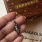 Hand holding a Ganesha face big silver pendant, pure silver 925, with a decorative wooden box in the background.