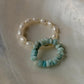 Natural Crystal stretchy rings featuring Fresh Water pearl and Larimar gemstones on a soft background.
